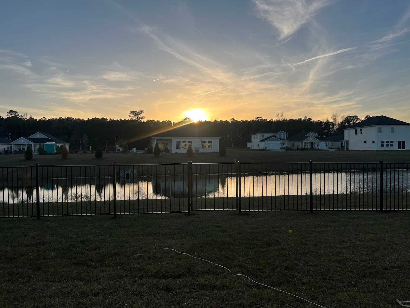 Sunset over fence by water